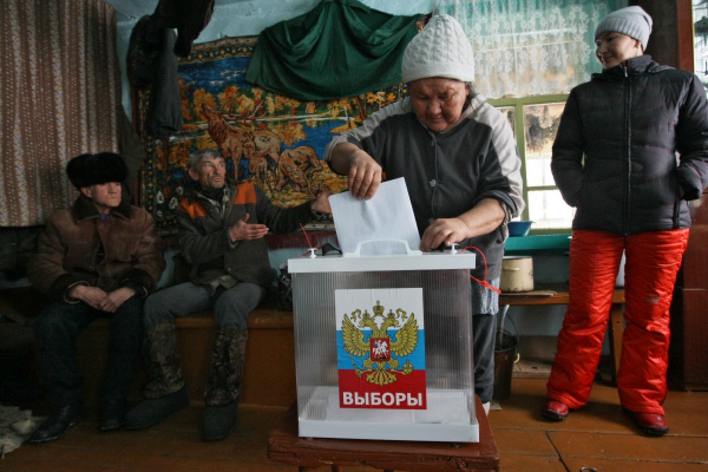 Жители села Новотроицк (республика Алтай) во время процедуры досрочного голосования на выборах в Государственную думу РФ в собственном доме, куда члены участковой избирательной комиссии доставили урну